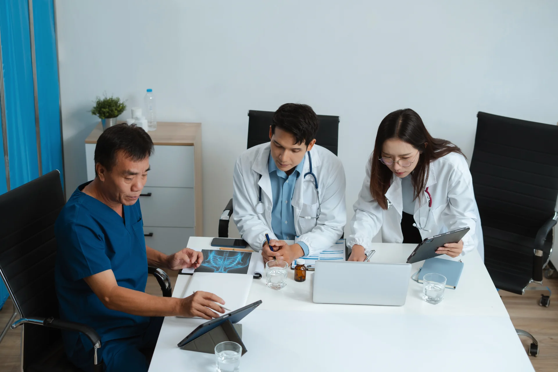 people gathered in an office deciding on treatment for the patient