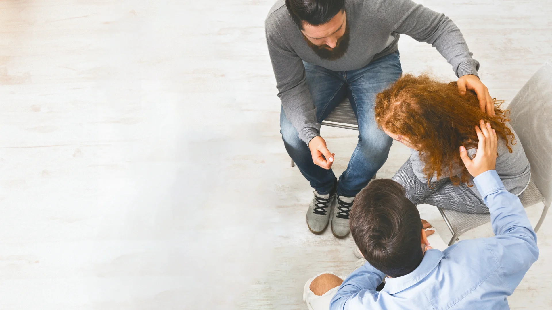 Person receiving emotional support from intervention professionals in a compassionate setting, highlighting the importance of guided interventions for addiction recovery.